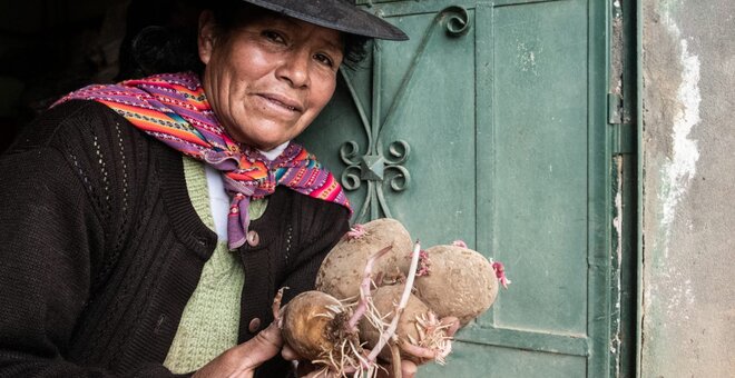 Woman holding potatoes.
