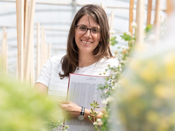 Woman standing near plants.