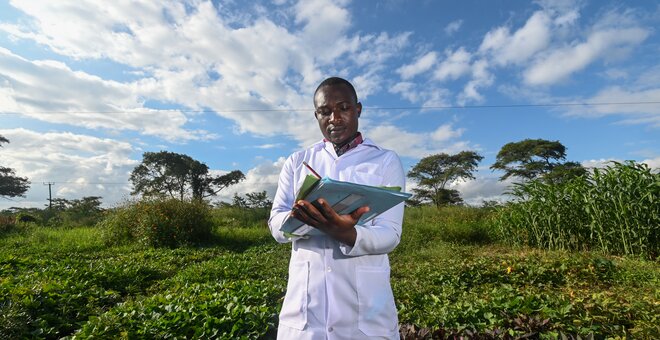 Man taking notes in a field.