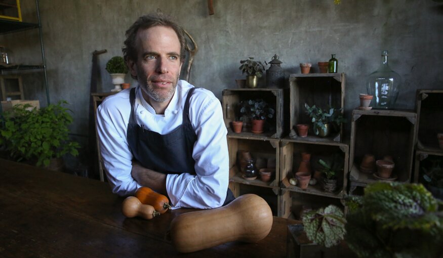 Man sat at table with root vegetables