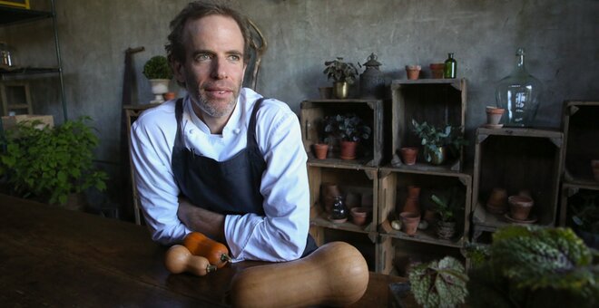 Man sat at table with root vegetables