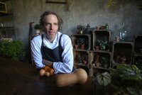 Man sat at table with root vegetables