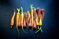 Photo of carrots against black background.