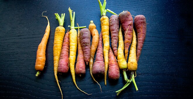 Photo of carrots against black background.