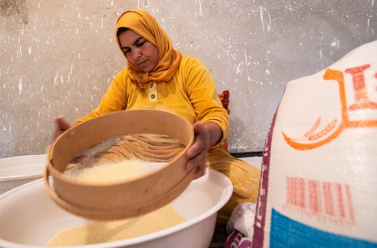 Woman holding basket with rice. 