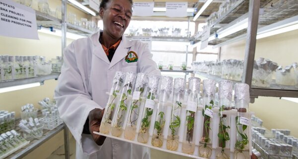 Woman holding rack of test tubes.