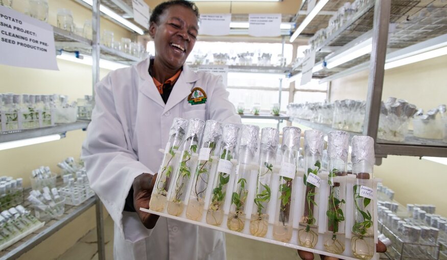 Woman holding rack of test tubes.