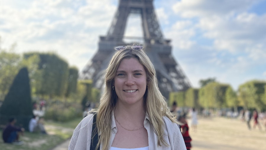 Woman standing in front of the Eiffel Tower.