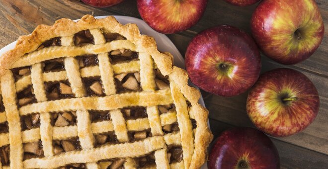 Apple pie with apples filling and rolling pin. Homemade apple pie. Rustic apple pie with cinnamon and fresh fruits.