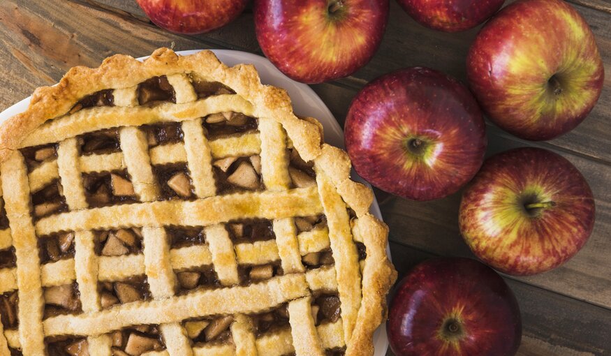 Apple pie with apples filling and rolling pin. Homemade apple pie. Rustic apple pie with cinnamon and fresh fruits.