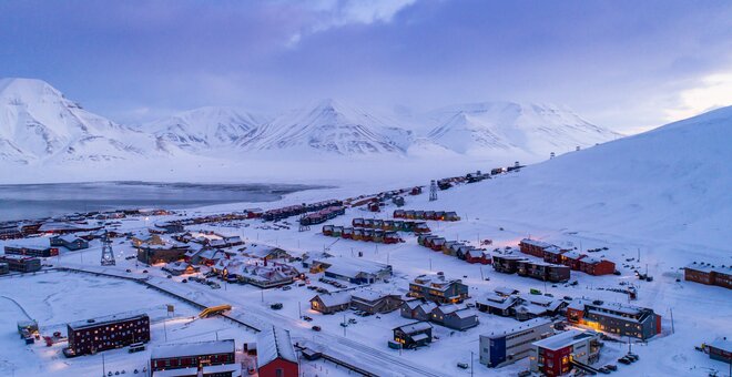 Small town surrounded by snowy mountains.