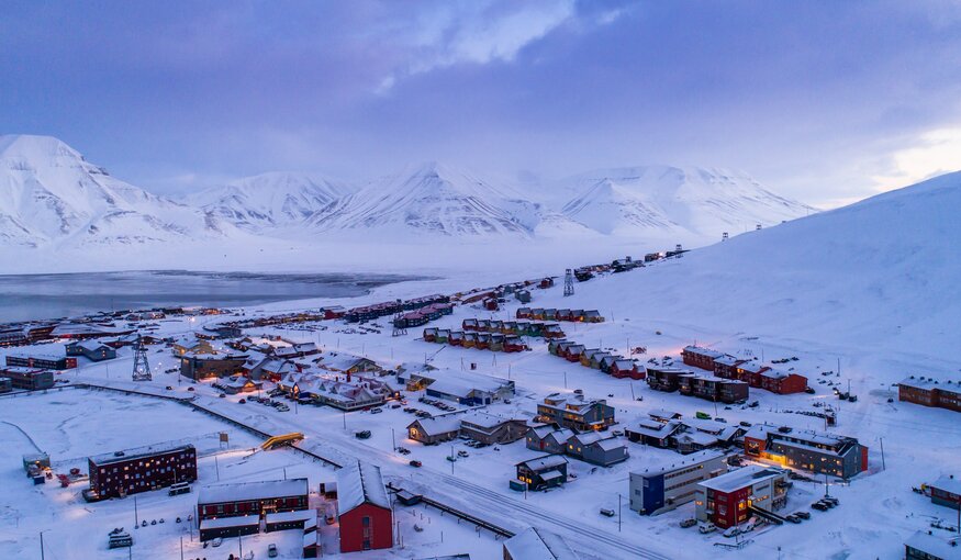 Small town surrounded by snowy mountains.