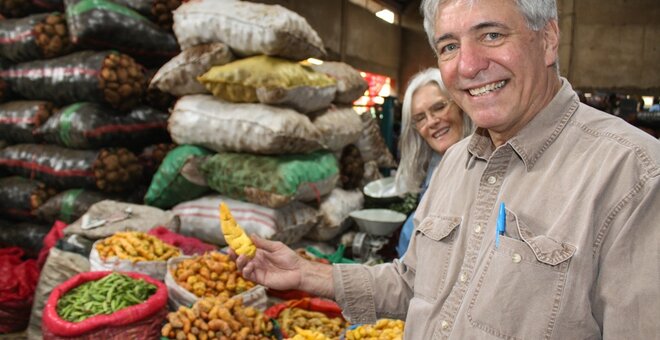 Dr. Ellis standing in front of potato varieties.