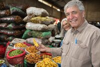 Dr. Ellis standing in front of potato varieties.