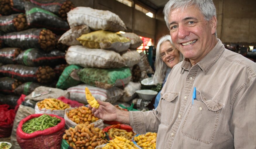 Dr. Ellis standing in front of potato varieties.