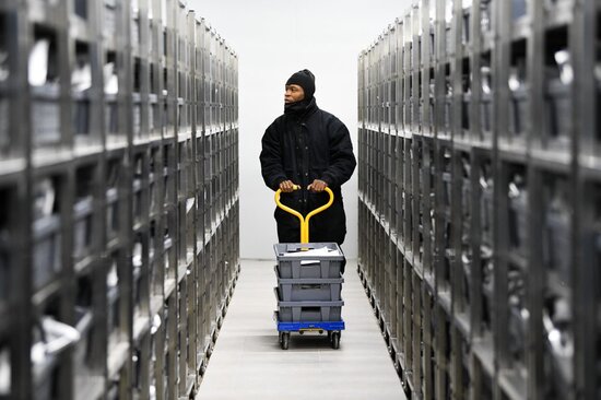 A genebank worker take seed packets to the shelves in the new AfricaRice genebank in Mbe