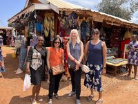 Group standing in front of a market. 