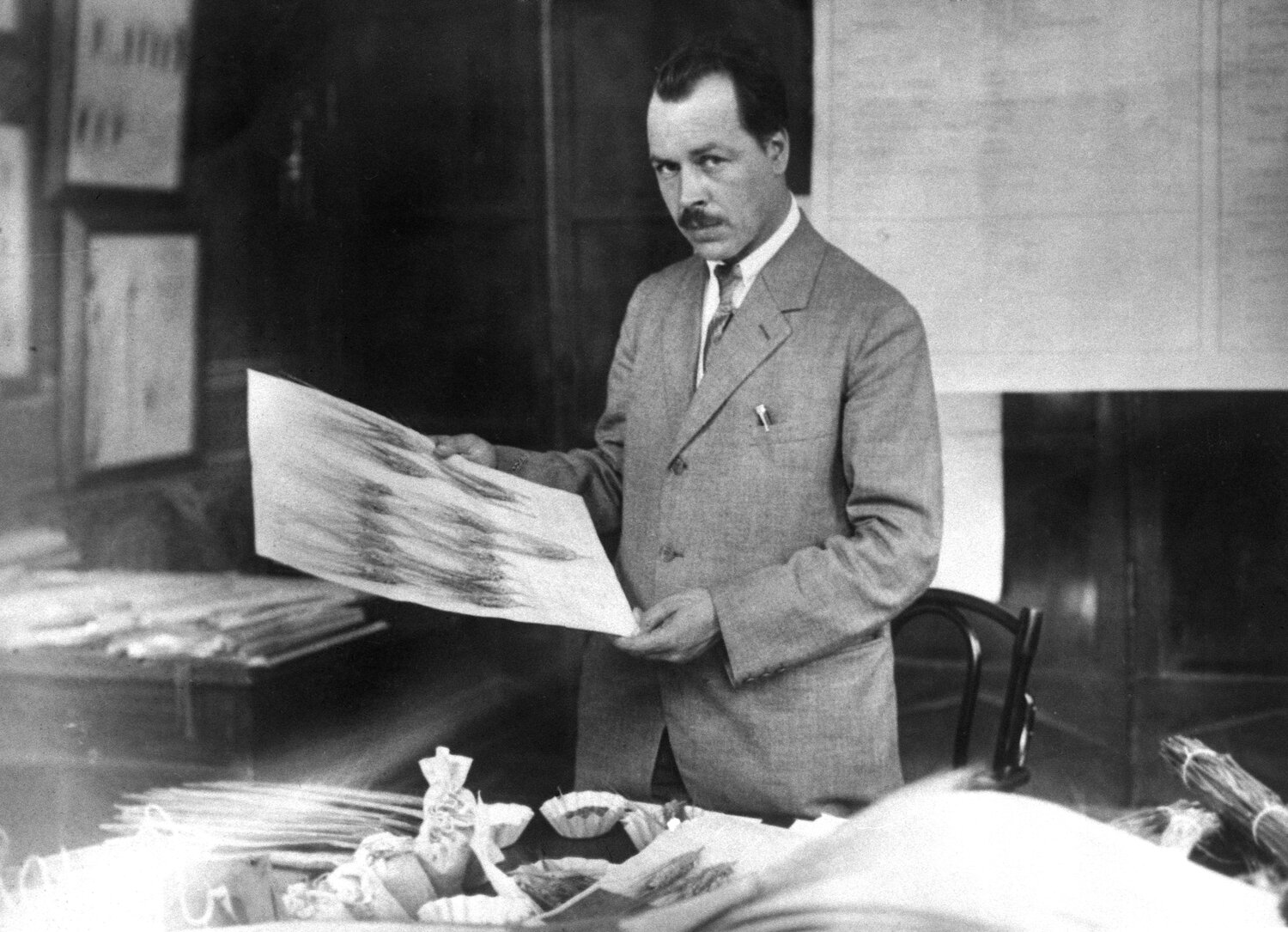 Nikolai Vavilov examining wheat herbarium specimen during preparation to the next expedition (1930).