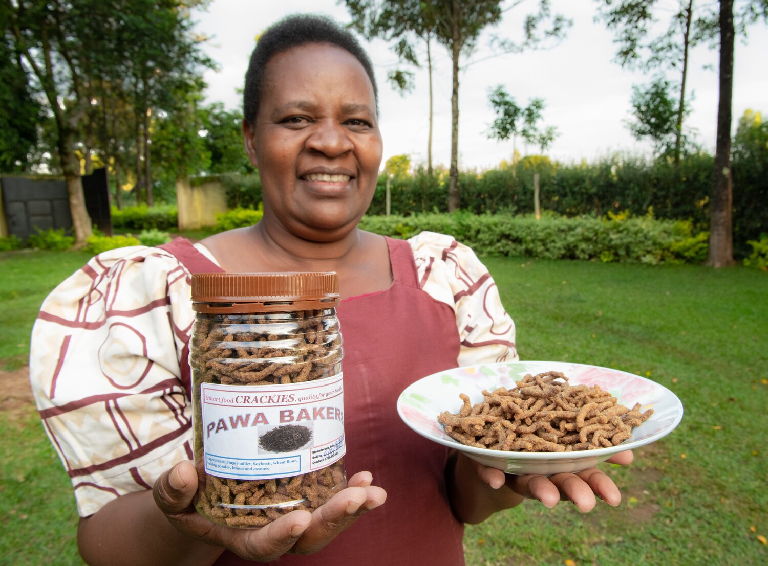 Farmer Pascilisa Wanyonyi holding her product ‘crackies’ under her brand name PAWA Bakers made with finger millet.
