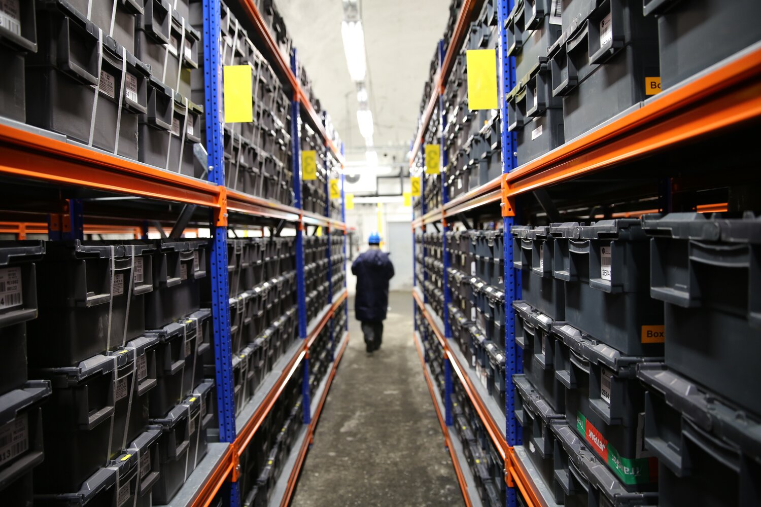 Shelves of black containers in Seed Vault aisles