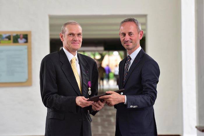 Dr. Debouck standing with another man holding an award. 