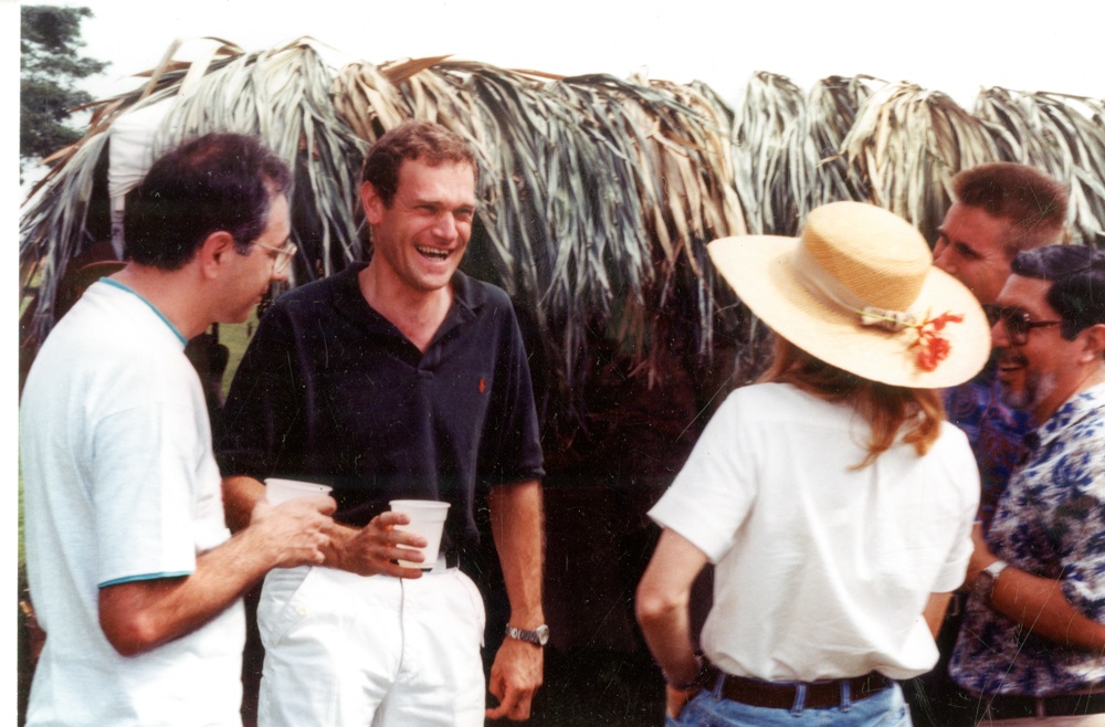 Dr. Debouck surrounded by a group of people outdoors.